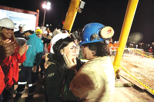 Chilean miner Osman Araya (R) is welcomed by his wife Angelica as he comes out of the Fenix capsule after being brought to the surface this morning following a 10-week ordeal in the collapsed San Jose mine, near Copiapo, 800 km north of Santiago, Chile. Araya was the sixth from the 33 trapped miners to be lifted from underground. AFP photos.