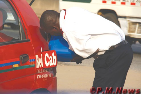 A Taxi driver filling his car with fuel bought from black market despite the call off strike by NUPENG workers today. PHOTOS: Idowu Ogunleye.