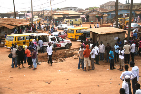 Residents discussing in groups at scene of the clash in Iju Ishaga this morning. Inset: One of the suspected hoodlums arrested by the police. PHOTOS: Olatunji Obasa.