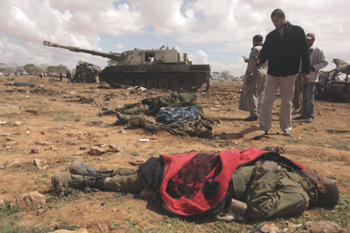 â€¢Curious Libyan onlookers take pictures of dead African teenagers, members of Moamer Gaddafi forces in al-Wayfiyah, west of Benghazi, hit by French war planes. PHOTOS: AFP.