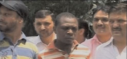The Nigerian, Innocent Nwayo, with New Delhi Police officers after his arrest for killing his girlfriend.