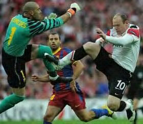 Wayne Rooney of United (right) fight for the ball with Barca keeper during today’s final match at Wembley stadium.