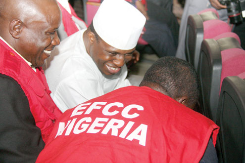 Dimeji Bankole sandwiched by EFCC officials in court. PHOTO: FEMI IPAYE.