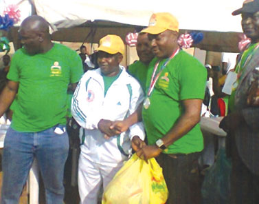 Table Tennis winner, Samuel Akande (right) receives gifts from Unity Community Chairman, Prince Adeniyi (middle) while Plant Manager, Golden Noodles, Gboyega Alabi looks on at the final of Alagbole Unity Games last weekend.