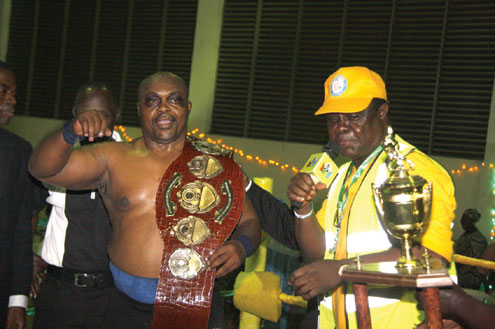 Royale Rumble winner, Banilux Bulldog of Scotland receives his belt and trophies from Primate Charles Odugbesi (right), Chairman of the LOC at the end of the BRF Wrestlemania 2011 in Lagos on Friday. Photo: Emmanuel Osodi.