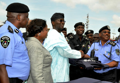 Lagos State Governor, Mr. Babatunde Fashola SAN (middle) presenting the Walkie Talkies/Batteries, Bullet Proof Jackets to the AIG Zone II, Mr. Sulaimon Fakai representing the IG, Mr. Hafiz Ringim (right) and the Commander RRS Ikeja, Mr. Akeem Odunmosu (2nd right) during the handing over of the Armored Personnel Carrier (APCs), Patrol Vehicles, RRS Mobile Workshop, Walkie Talkies/Batteries, Bullet Proof Jackets and presentation of newly trained RRS drivers at the Lagos House, Ikeja, on Tuesday, October 25, 2011. With them are: Deputy Governor, Hon (Mrs.) Adejoke Orelope-Adefulire (2nd left) and the Lagos State Commissioner for Police, Mr. Yakub Alkali (left).