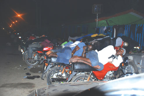 Mobile Beds: Homeless Okada Riders sleep on thier bikes infront of Dodan Barracks, Obalende Lagos, Southwest Nigeria at 3am this morning. Photo: ABEEB OGUNBADEJO.