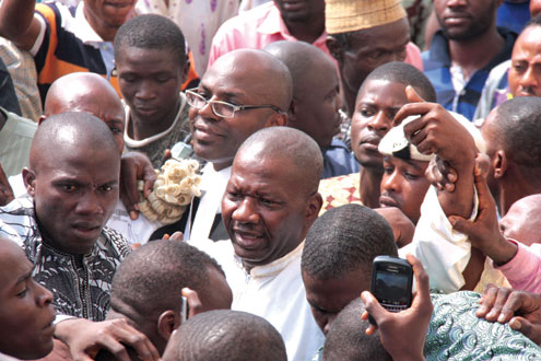 Baba Suwe sandwiched by his supporters and lawyer