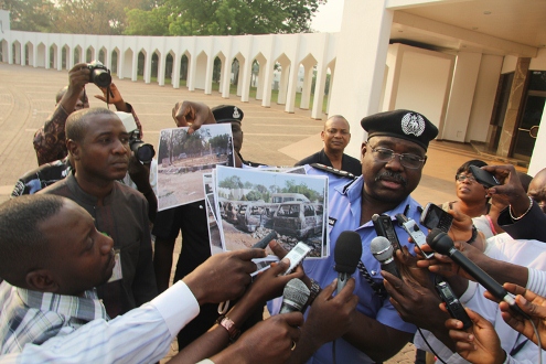 SECURITY & SECURITY1: Inspector General of Police, Mr. Hafiz Ringim displaying photographs of the damaged properties at the Kano State Government House after a Security Meeting at the State House, Abuja.  10/01/2012