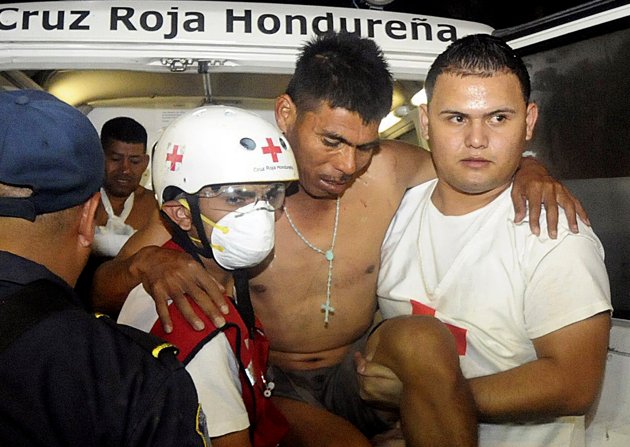 An injured inmate is carried as he arrives at the hospital after a fire broke out in a Honduras prison.