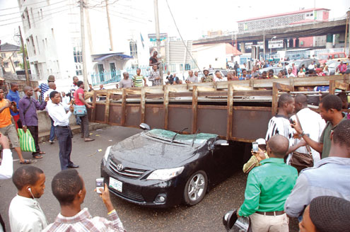•A Toyota Camry car damaged by a large signpost during the storm at Obalende, Lagos this morning.