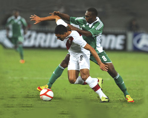 •GRITTY…Peru’s Jesus Alvarez (left) struggles for the ball with Kalu Uche (right) of Nigeria during a friendly match in Lima in the early hours of today. Peru won 1-0. PHOTO: AFP.