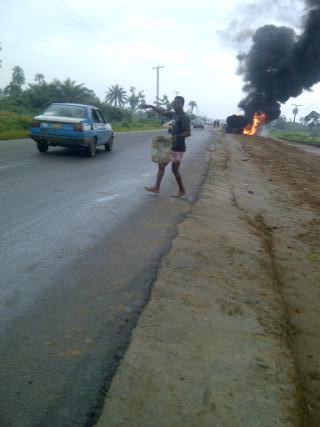 A youth carrying Petroleum product leaking from the burning tankers