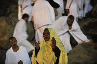 a pilgrim prays at Mount Arafat