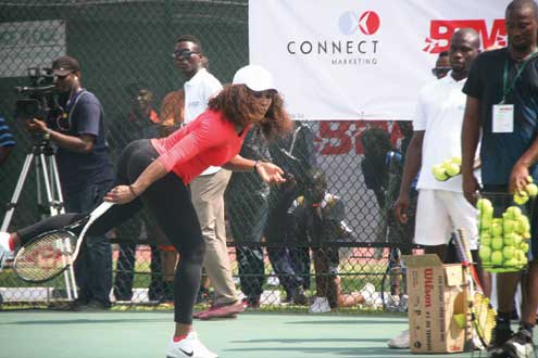Serena Williams return a serve to one of the kids.