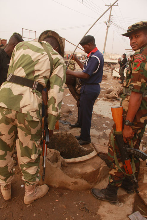 A Paramilitary official with other Military officials fetching Kerosene (DPK) found in a water well. Photos: Femi Ipaye