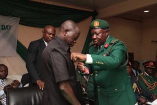 Governor Adams Oshiomhole being decorated with the remembrance emblem