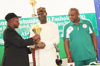 MD of Guinness, Seni Adetu presents the cup to fashola