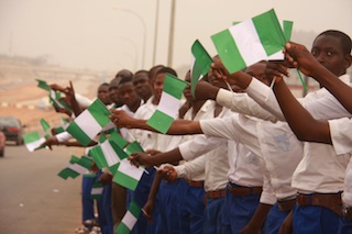 Students line the airport road in Abuja