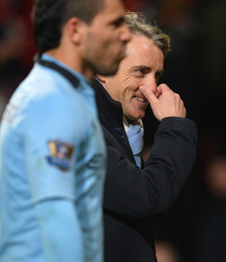 Mancini gestures as he leaves Old Trafford