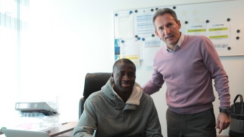 Yaya Toure with a club official. Photo credit: Man City website