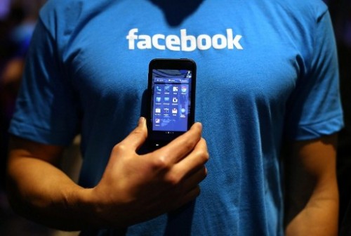 A Facebook employee holds a phone that is running the new "Home" program during an event at Facebook headquarters in April 2013