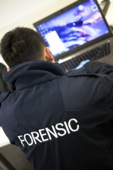 Forensic  officer examines the hacker's computer