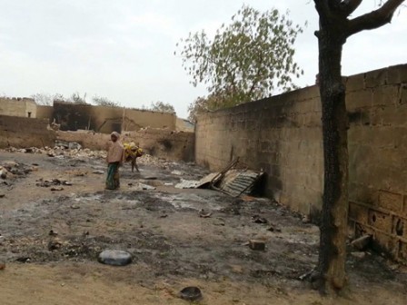A young girl stands amid the burnt ruins of Baga, Nigeria, on Sunday, April 21, 2013. Fighting between Nigeria's military and Islamic extremists killed at least 185 people in a fishing community in the nation's far northeast, officials said Sunday, an attack that saw insurgents fire rocket-propelled grenades and soldiers spray machine-gun fire into neighborhoods filled with civilians. (AP Photo/Haruna Umar)