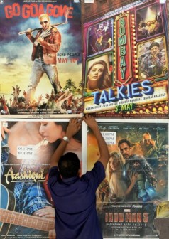 An Indian employee of the New Excelsior Theatre prepares to remove a poster from a display board in Mumbai on May 3. AFP Photo