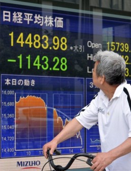 Tokyo share crash: a man looks at a share prices board. AFP