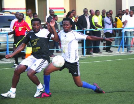 Former Eagles' captain,  Austin Okocha (left) fights for the ball with one of the showbiz  players during a match to celebrate Fred Amata's birthday at Campus Square, Lagos Island, yesterday.  Inset is Amata with the MVP  award after the match.  Photo:  Emmanuel Osodi.