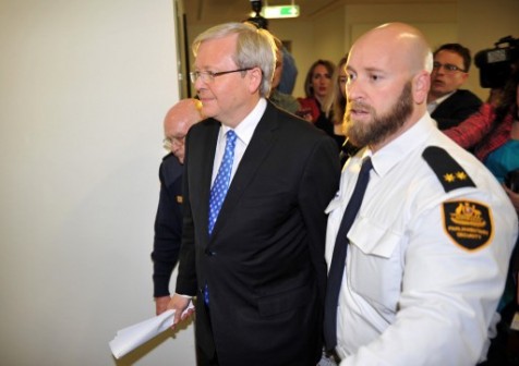 Former Australian Prime Minister Kevin Rudd (C) is escorted by security guards in Parliament House, Canberra on June 26, 2013, after leaving a press conference stating he will challenge Prime Minister Julia Gillard in a caucus vote for leadership. 