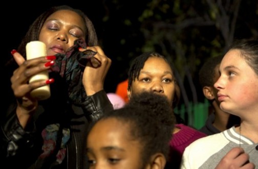 A well wisher (L) wipes a tear during a candle lit vigil outside the Mediclinic Heart Hospital in Pretoria where a community group prayed and sang religious songs in support of Nelson Mandela who is receiving treatment there, on June 25, 2013