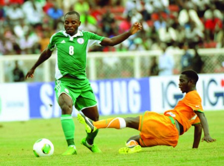 NARROW ESCAPE...Nigerian midfielder Sunday Mba (L) tries to beat Ivorian defender Topio Coulibaly during the 2014 CH AN qualification match in Kaduna 6 July, 2013. Nigeria defeated Ivory Coast 4 - 1 at the end of regulation time.  AFP PHOTO.