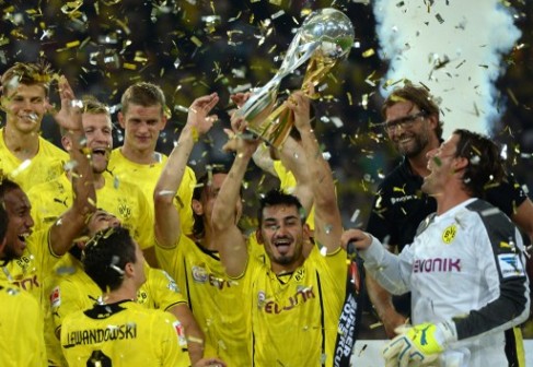 Dortmund's midfielder Ilkay Guendogan lifts up the trophy after winning the German Supercup football match Borussia Dortmund vs Bayern Munich 4-2  in the German city of Dortmund on July 27, 2013. AFP 