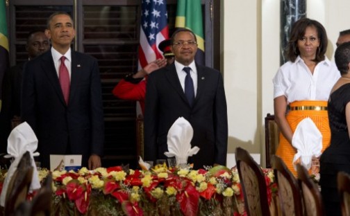 Tanzanian President Jakaya Kikwete (C) stands alongside US President Barack Obama (L) and US First Lady Michelle Obama as a band plays the Tanzanian National Anthem during an official dinner at the State House in Dar Es Salaam, on July 1, 2013.