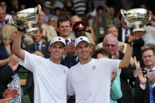 US players Bob (L) and Mike (R) Bryan pose with their winners' trophies after beating Croatia's Ivan Dodig and Brazil's Marcelo Melo in the men's doubles final match on day twelve of the 2013 Wimbledon Championships tennis tournament at the All England Club in Wimbledon