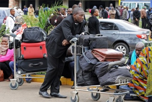 Stranded passengers wait outside the Jomo Kenyatta International Airport in Nairobi on August 7, 2013. A massive fire shut down Nairobi's international airport on Wednesday with flights diverted to regional cities as firefighters battled to put out the blaze in east Africa's biggest transport hub.