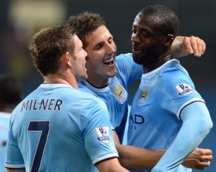 Manchester City's Yaya Toure (R) celebrates with  Stevan Jovetic (C) and  James Milner (L) after scoring the third goal during the League Cup football match 