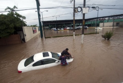 Two men wait for help in a flooded street in Acapulco, Guerrero state, Mexico, after heavy rains 