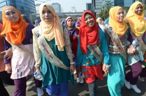 Contestants of the World Muslimah contest, Nanzin Sultana Liza (C, red headscarf) of Bangladesh, Obabiyi Aishah (R) of Nigeria and others from Indonesia take part in a fun walk in Jakarta on September 15, 2013. The Muslimah World contest to be held on September 18 in the Indonesian capital, Jakarta, is "Islam's answer to Miss World", the pageant's founder Eka Shanti said on September 15. AFP PHOTO