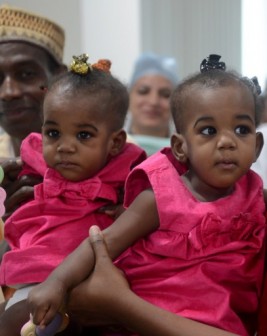 Badaru Mannir (L) holds his daughter Hassana Badaru (2L) while Hussaina Badaru (R) is held by her mother, after a surgery to separate the conjoined twins at BLK Super Speciality Hospital in New Delhi on September 4, 2013. The twins were joined at the back. AFP photo service