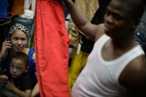 Lamine Ibrahim (R) from Guinea smiles as his Chinese wife Maryam Barry (L) looks on with their son at their shop inside a clothing wholesale market in Guangzhou.  