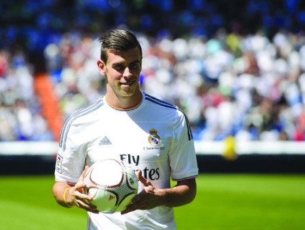 New Welsh striker of Real Madrid Gareth Bale poses on the pitch during his presentation at the Santiago Bernabeu stadium in Madrid on September 2, 2013. Bale was unveiled as a Real Madrid player today after his prolonged transfer from Tottenham Hotspur was finally completed for an unconfirmed world record fee late September 1. The Welshman has agreed a six-year deal believed to be worth 10 million euros net a year and will be presented to the media and the club's fans after undergoing a medical in the Spanish capital.   AFP PHOTO/ PIERRE-PHILIPPE MARCOU