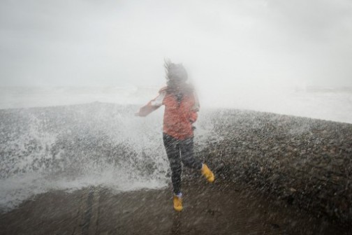 A woman is soaked as large waves crash against the walls of Brighton seafront, in southern England on October 27, 2013 as a predicted storm starts to build. Britain was braced on October 27 for its worst storm in a decade, with heavy rain and winds of more than 80 miles (130 kilometres) an hour set to batter the south of the country. AFP