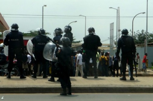 Angolan riot policemen stand in front of hundreds of demonstrators
