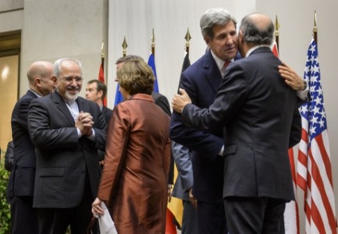 Iranian Foreign Minister Mohammad Javad Zarif (L) reacts next to EU foreign policy chief Catherine Ashton (C) as US Secretary of State John Kerry (2nd R) embraces French Foreign Minister Laurent Fabius after a statement on early November 24, 2013 in Geneva.AFP