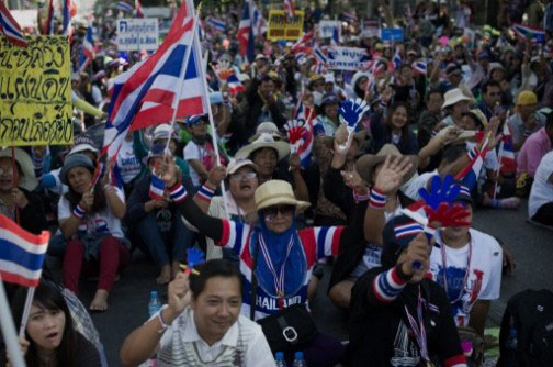 A Thai anti-government protesters wave national flags outside the customs department 