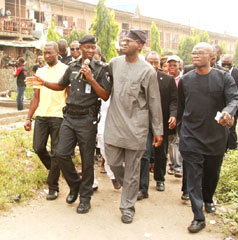 Lagos State Governor, Mr. Babatunde Fashola SAN (middle), being conducted round the Mosafejo Market by the Chairman, State Task Force, Chief Superintendent of Police (CSP), Adebayo Sulaimon (left) during the inspection of the market in Oshodi on Tuesday, January 7, 2014. With them are the Commissioner for Information and Strategy, Mr. Aderemi Ibirogba (right) and other members of the State Executive Council.
