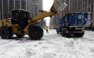 Snow removal trucks on 6th Avenue pick up snow on January 3, 2014 . AFP Photo